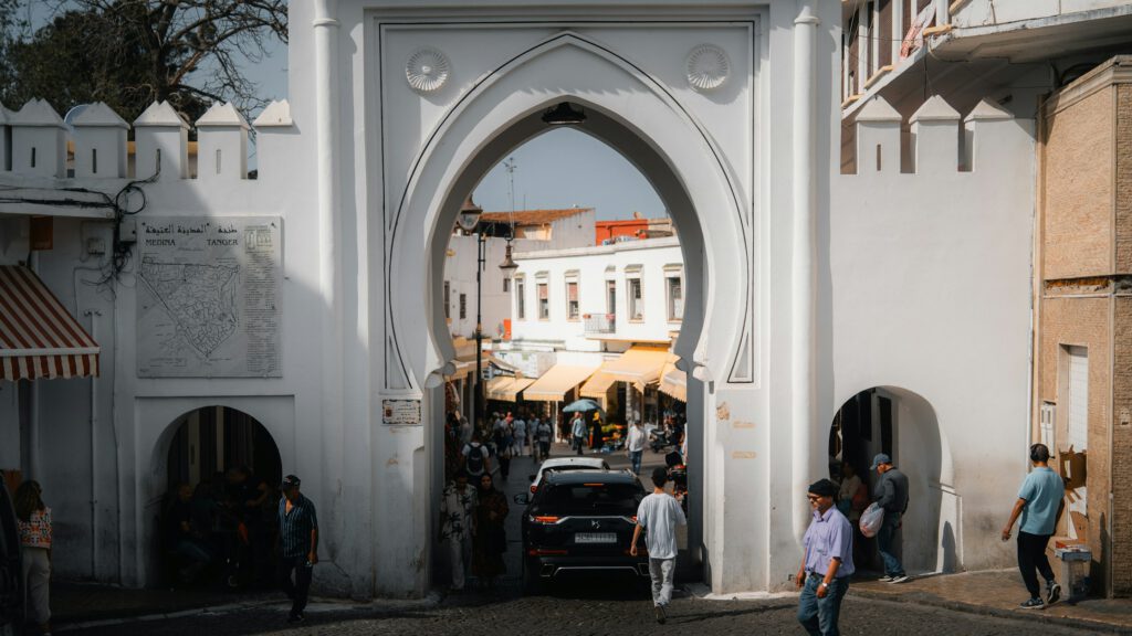Entrance gate to the Medina of Tangier with people walking through