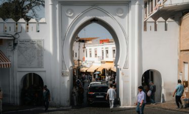 Entrance gate to the Medina of Tangier with people walking through